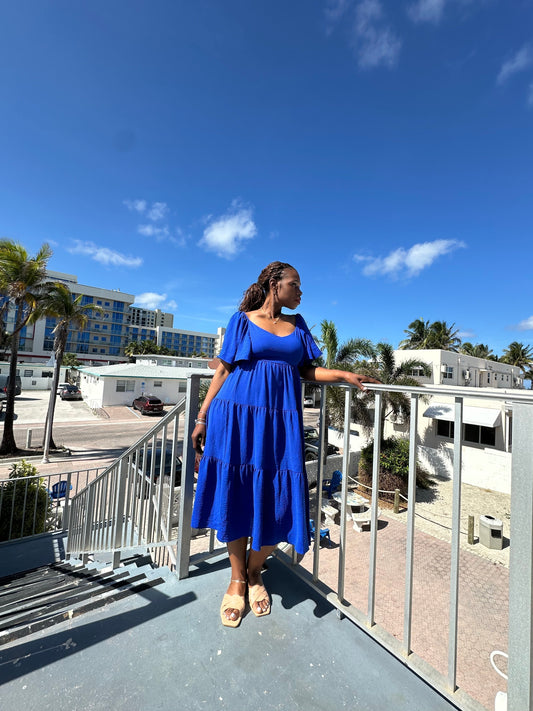Woman wearing royal blue Nicole dress overlooking Hollywood Ocean in Miami, stylish curvy fashion